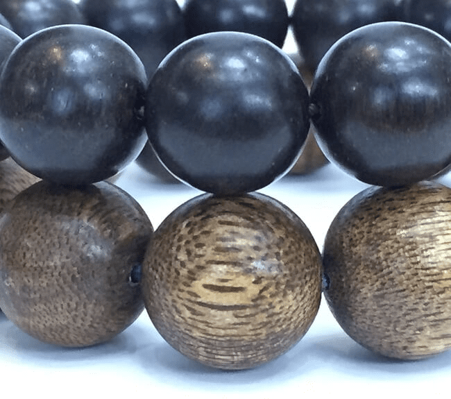 Natural agarwood features a color range from light yellow to deep brown with distinct wood grain patterns, while counterfeit products often appear dark black due to the injection of additional essential oil.