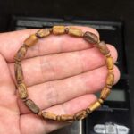 Tarakan agarwood bracelet with 8 mm cylindrical beads held in hand