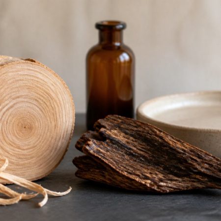 Unlabelled glass bottle with natural wood chips on a calm neutral surface
