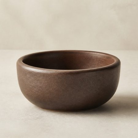 Plain empty brown ceramic mortar on a light neutral surface